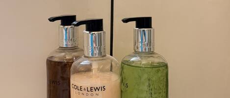 Three bottles of conditioner on a bathroom counter.
