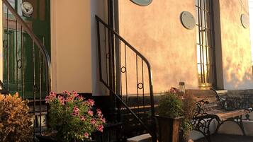 The exterior of The North Cliff Hotel with a reception sign, a staircase, and potted plants.
