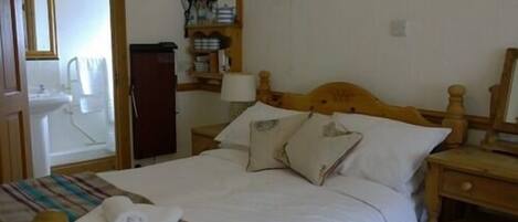 A neatly made bed with a striped blanket, a wooden headboard, and a bedside table with a lamp.