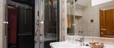 A modern bathroom with a glass-enclosed shower, a white sink, and a vanity with drawers.
