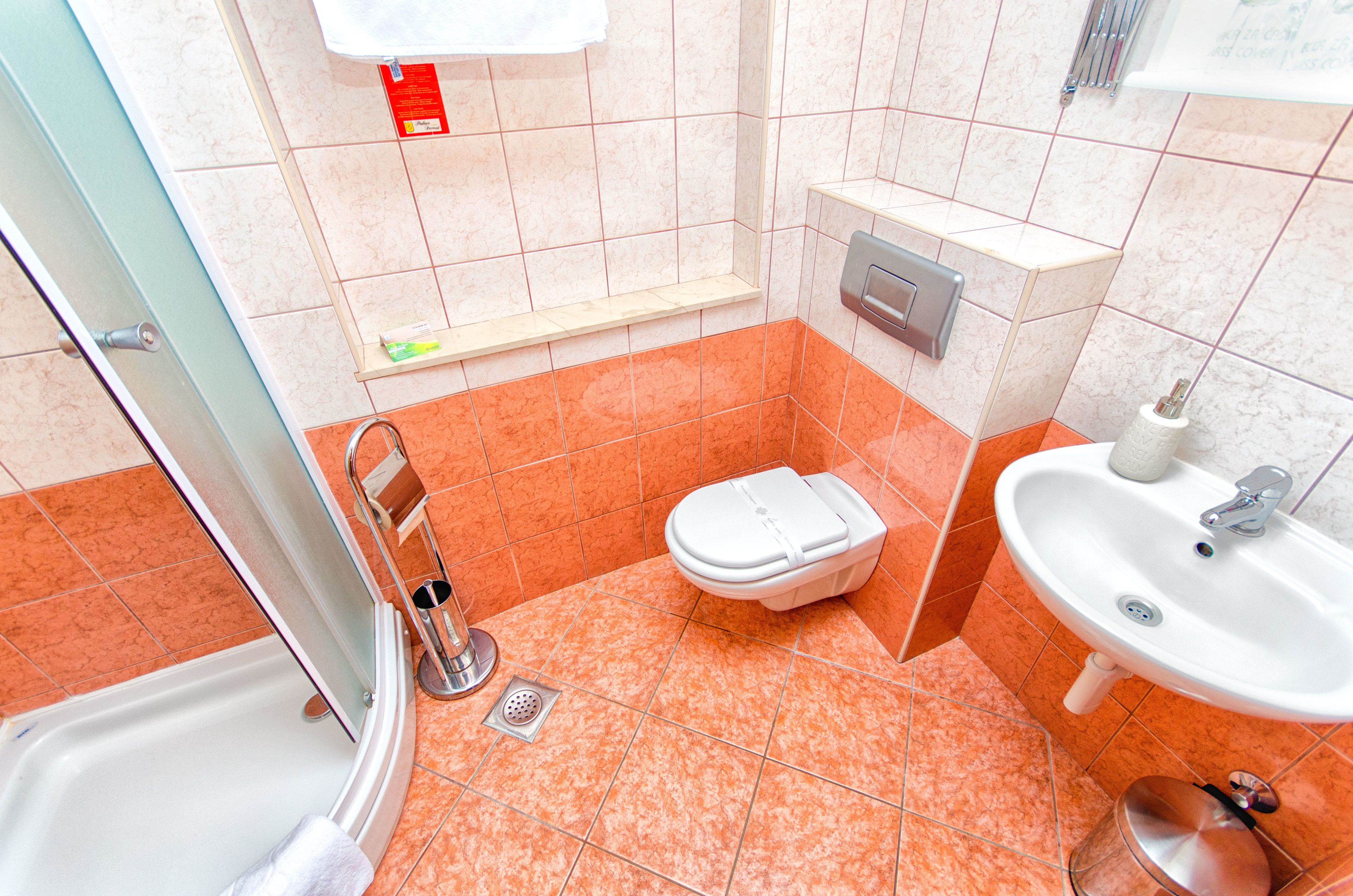 A bathroom with a shower, toilet, and sink.
