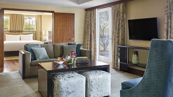 Una habitación de hotel con cama, sofá, mesa de centro y televisión.
