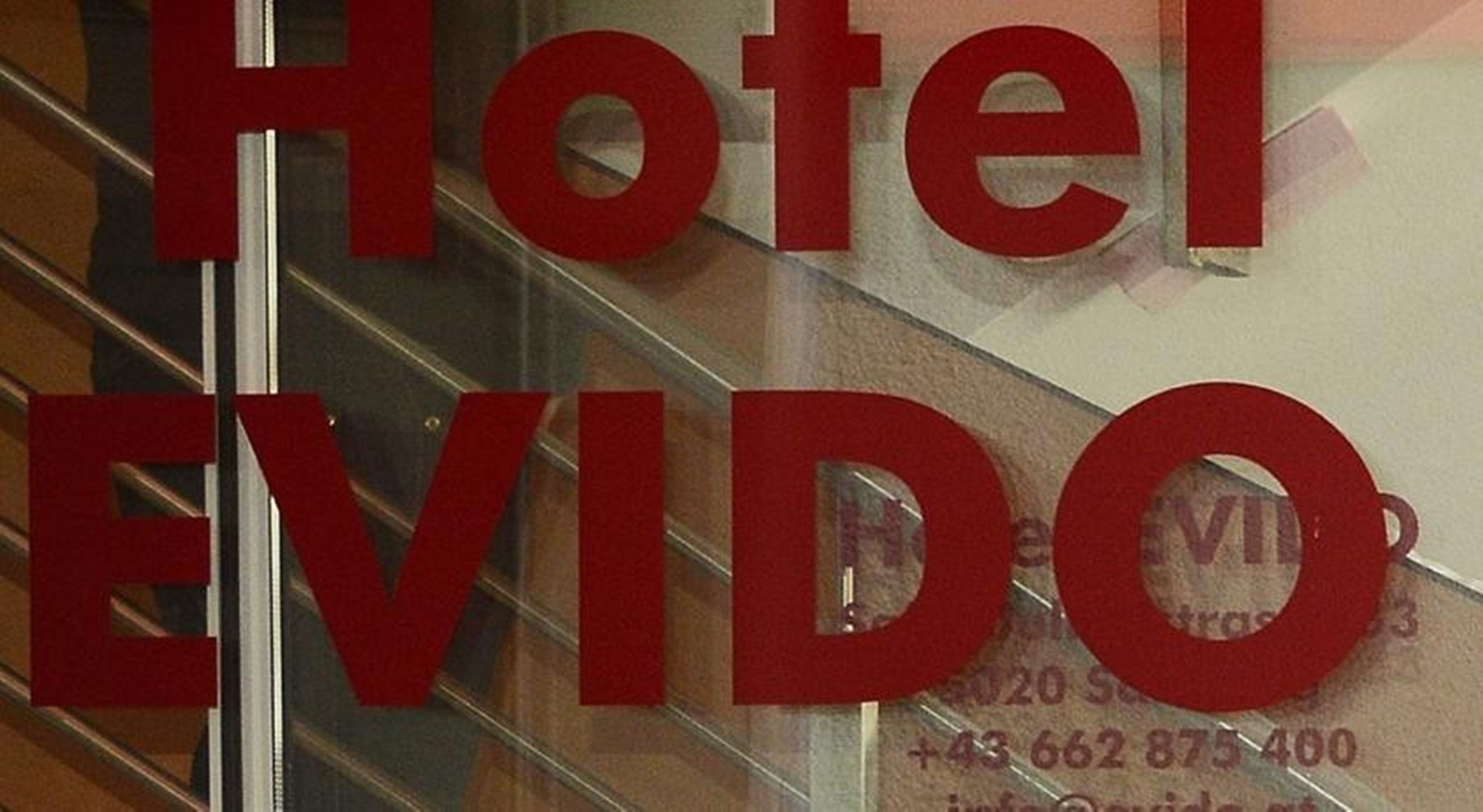 A hotel sign with the name 'Hotel EVIDO' and a phone number.