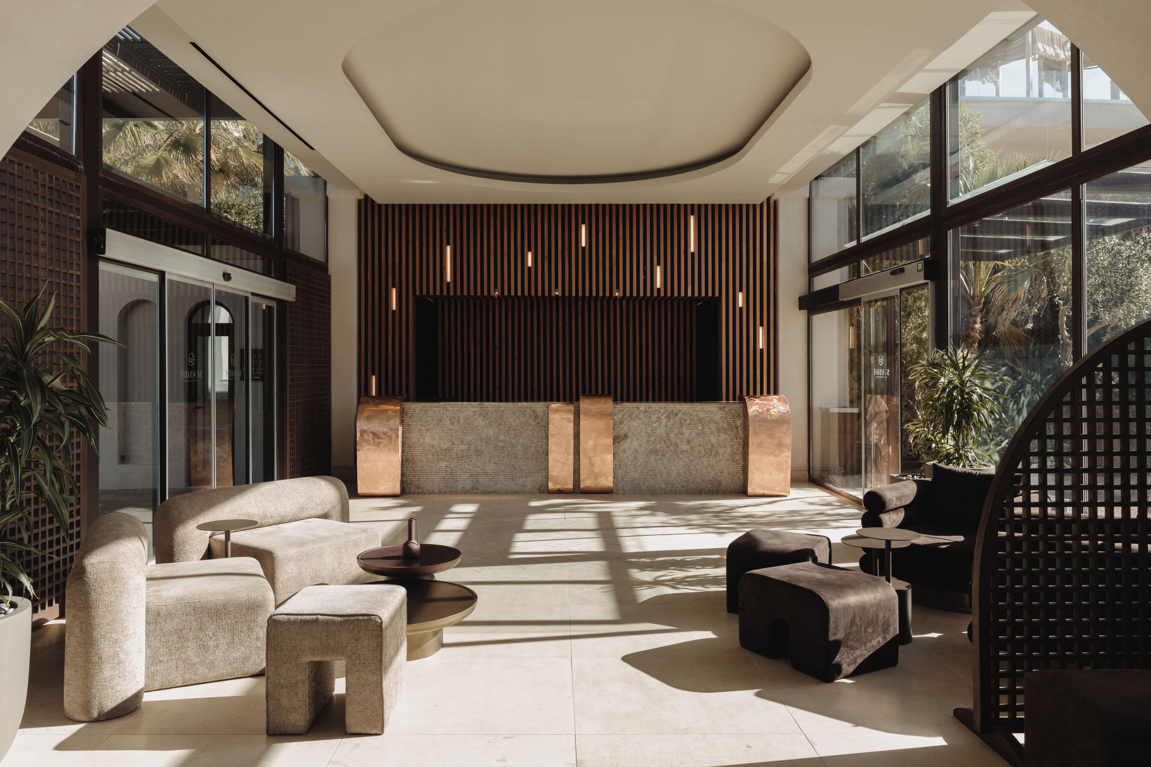 A modern lounge area with a sofa set, coffee table, and a decorative wall panel.