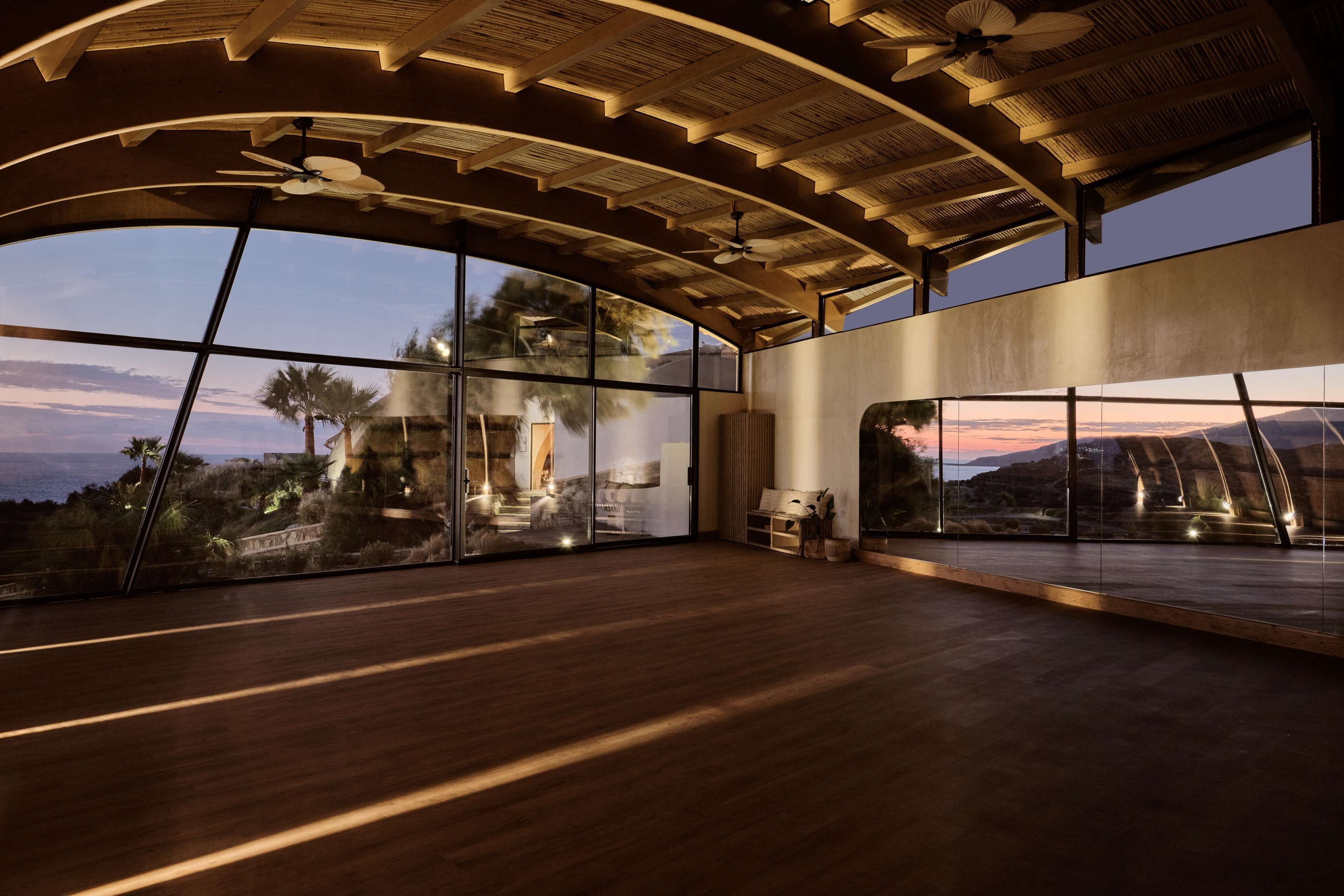 Una habitación amplia con ventanas grandes, techo curvo y vistas al paisaje.