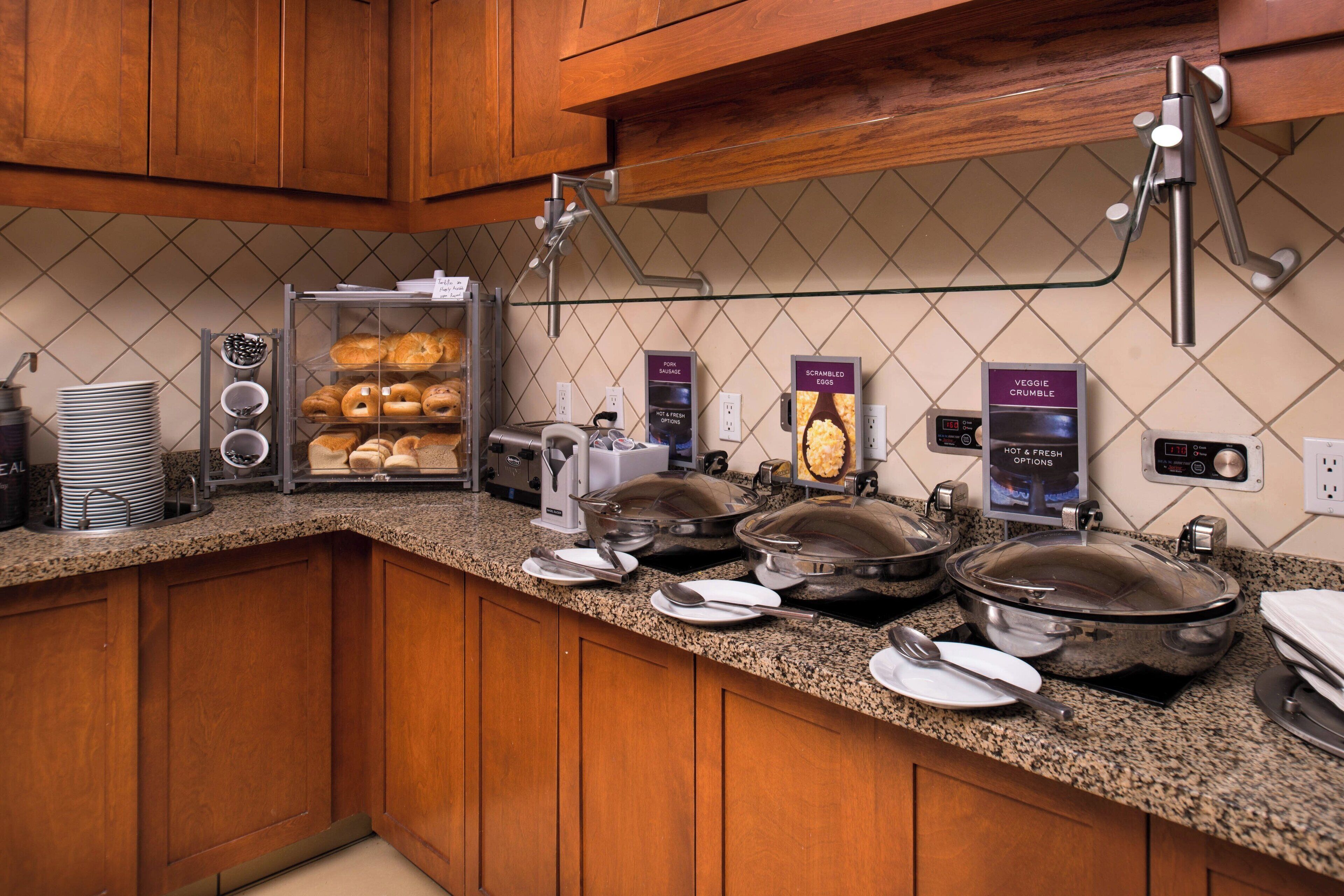 A breakfast buffet with various food items and a coffee machine.