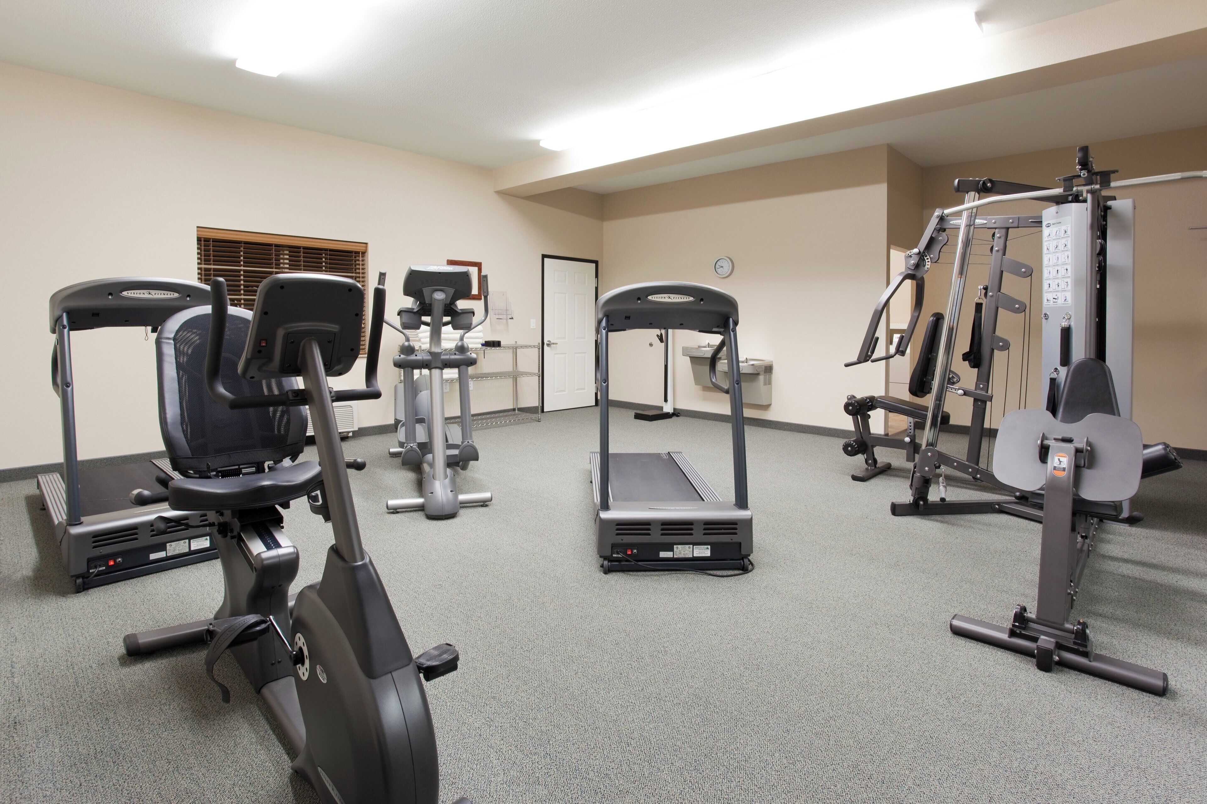 A fitness center with treadmills, elliptical machines, and weightlifting equipment.