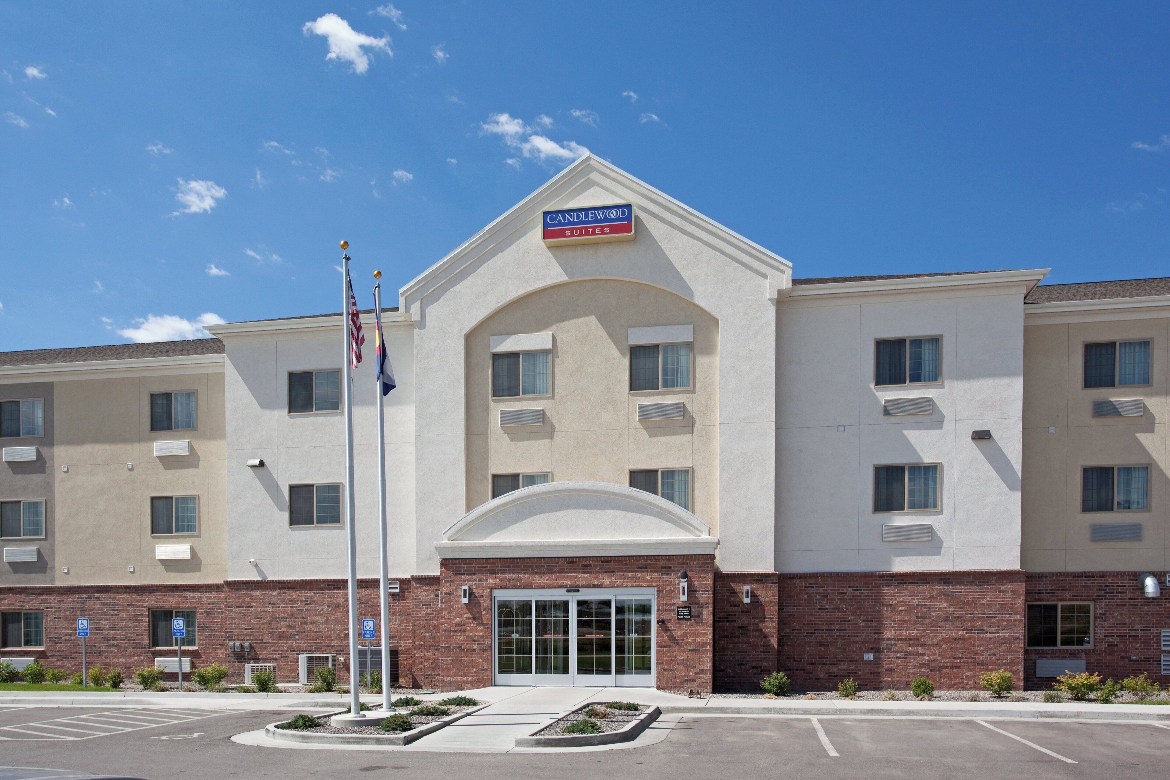 Un hotel con una entrada destacada, numerosas ventanas y un letrero que indica que es un Candlewood Suites.