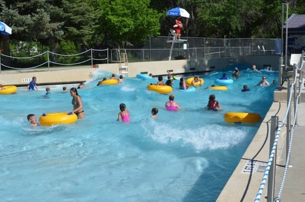 Una piscina con varias pistas, algunas con gente en flotadores y otras nadando.