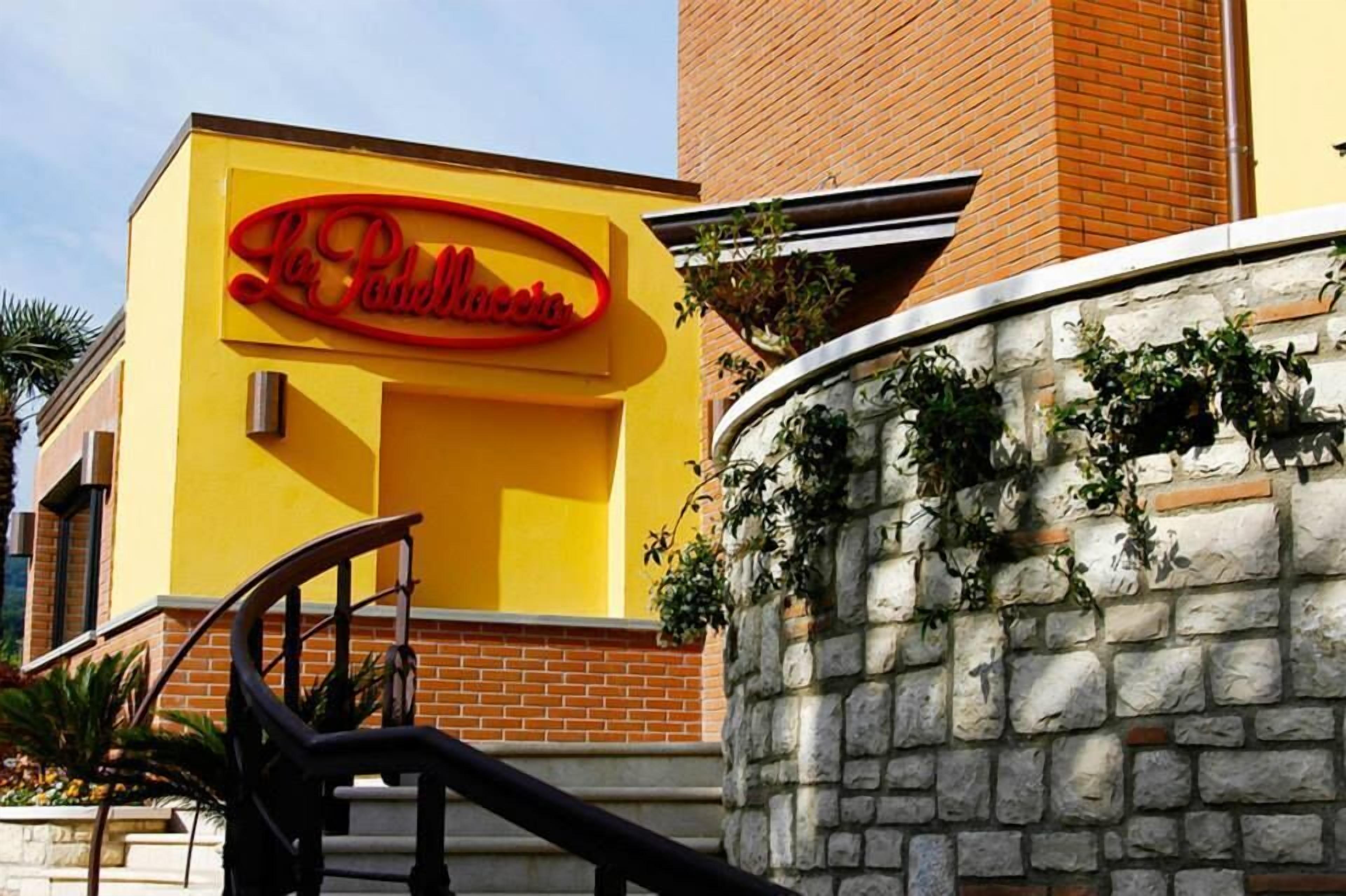 Un edificio giallo con un cartello rosso che riporta la scritta "La Posada".