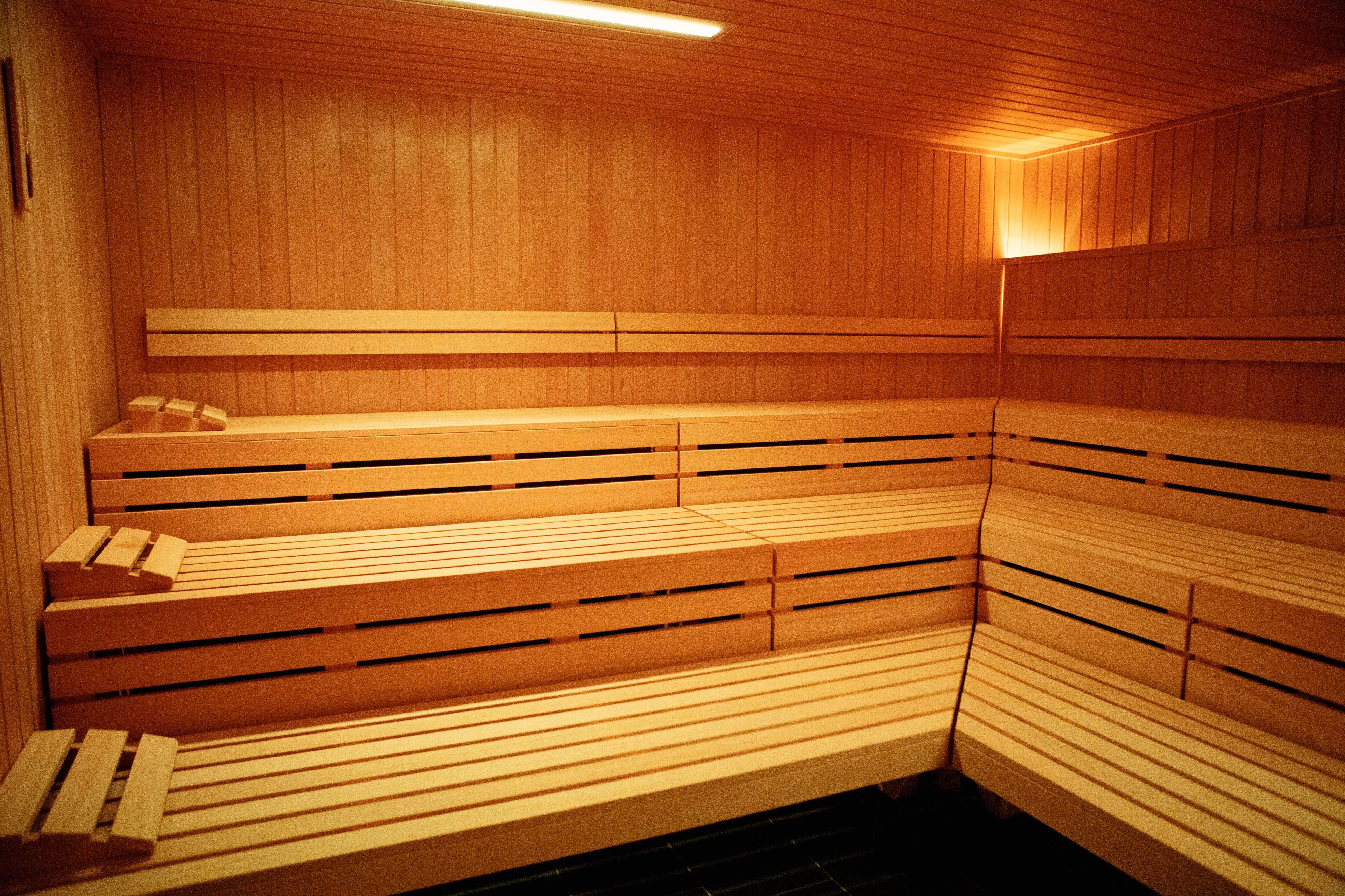 Un sauna avec des bancs en bois et un plafond incliné.