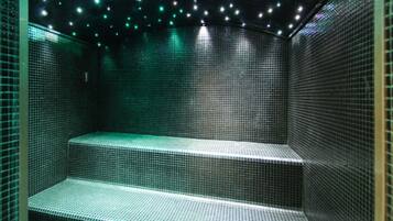 A tiled room with steps and a ceiling with small lights.