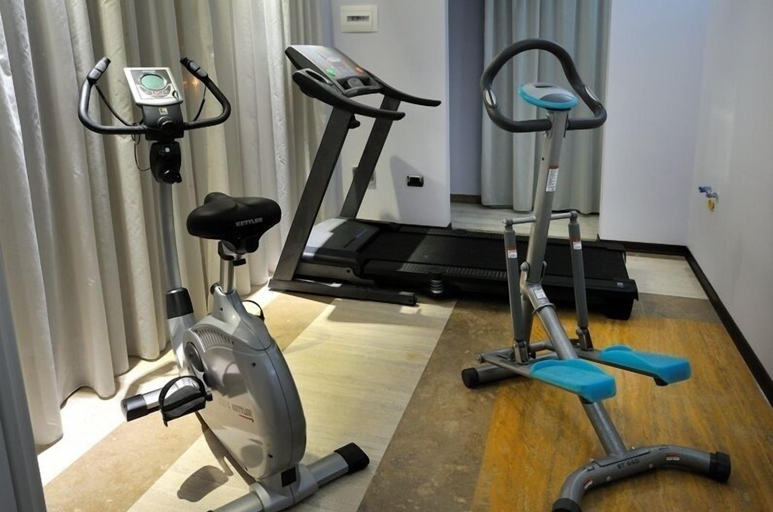 Et hotelværelse med motionscykel, løbebånd og stepmaskine.