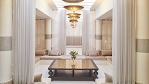 A spacious living area with a central coffee table, a sofa set, and a decorative hanging light fixture.