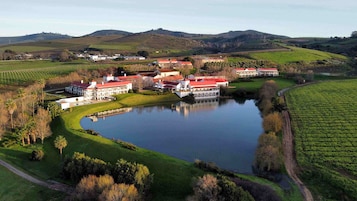 Una extensa propiedad con varias construcciones, un lago y campos circundantes.