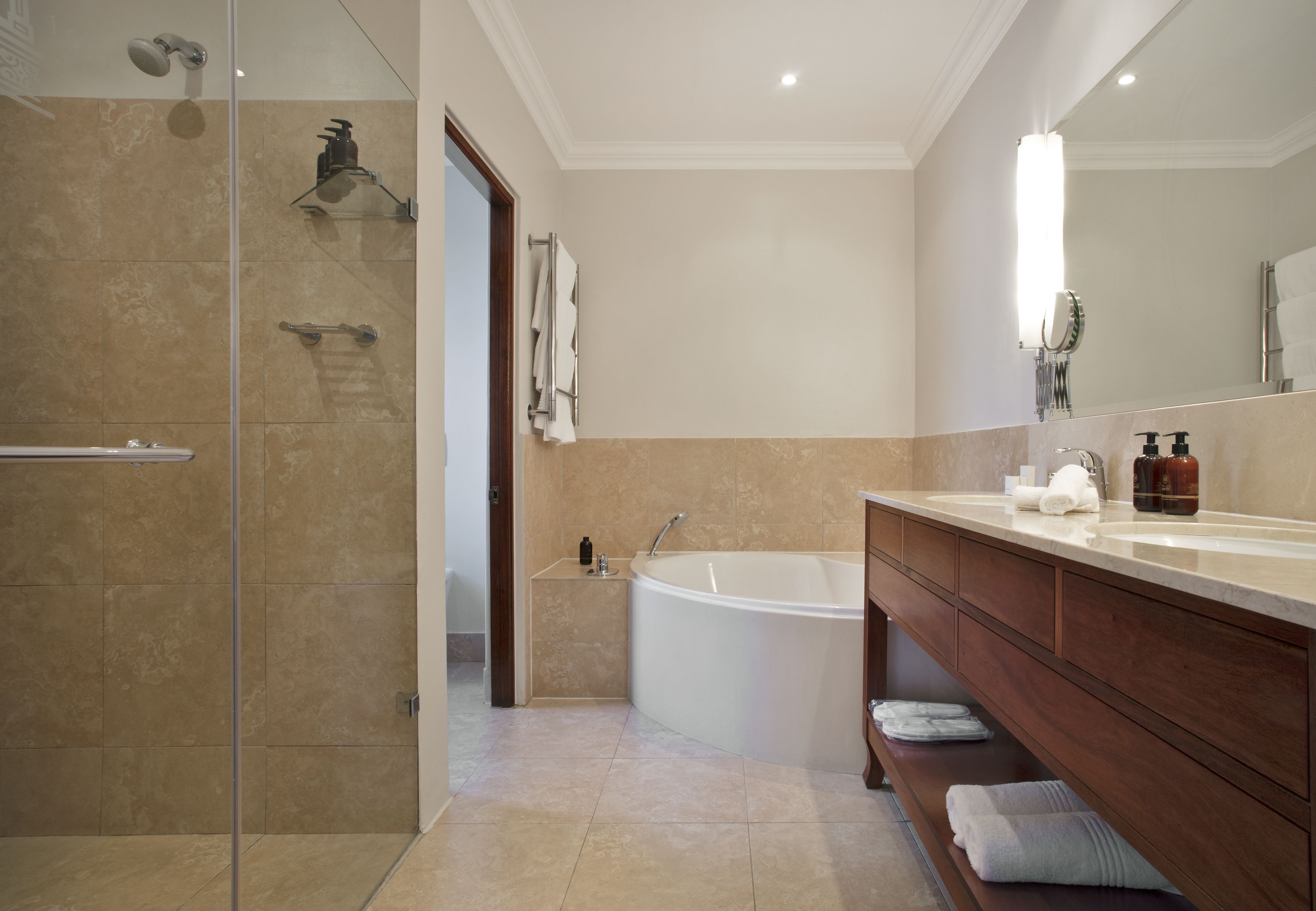 A modern bathroom with a glass-enclosed shower, a freestanding bathtub, and a vanity with a mirror.