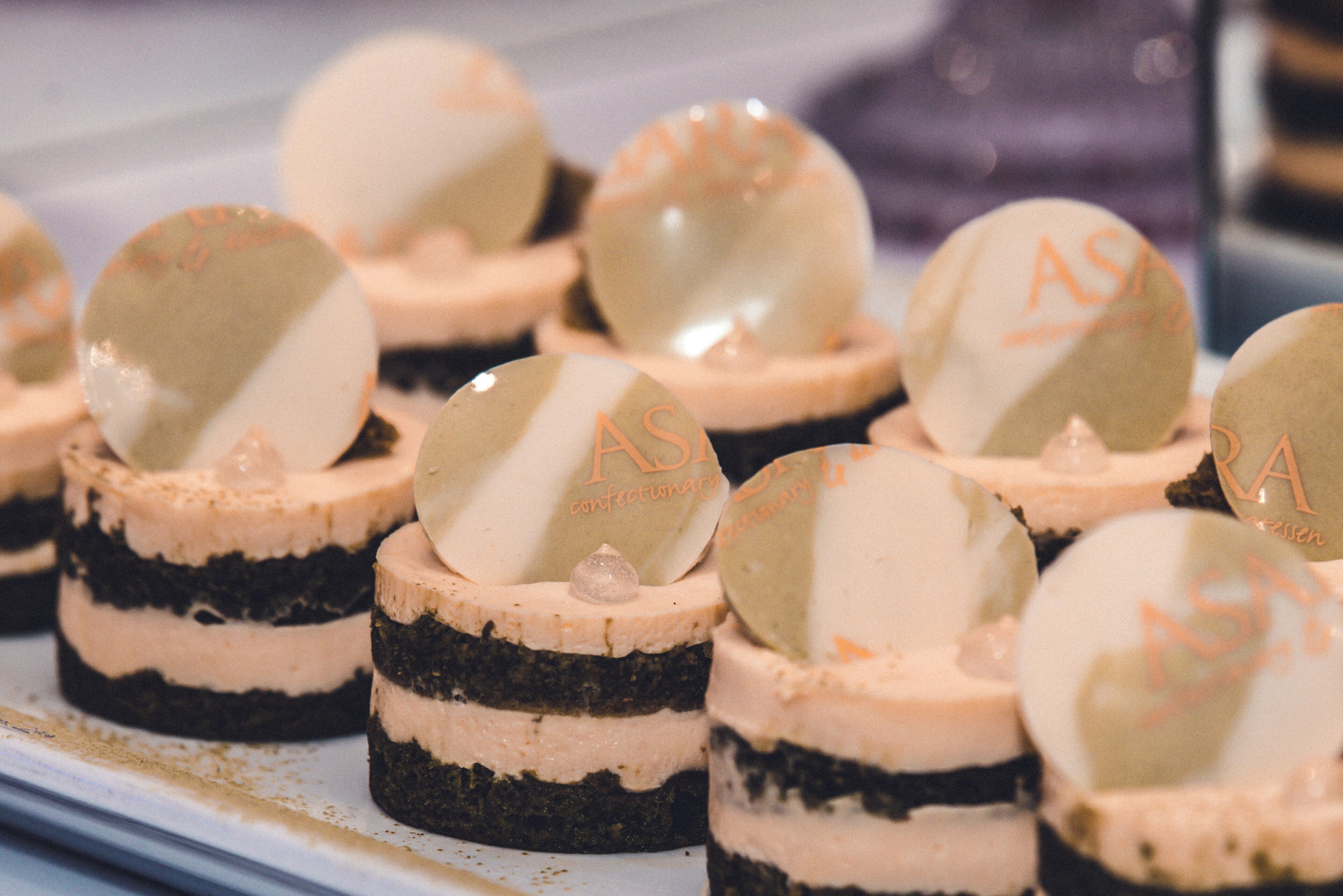 A display of layered desserts with a spherical topping labeled "ASA".