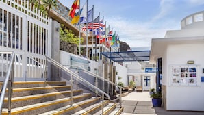 A hotel entrance with a staircase, multiple flags, and a 'Welcome' sign.