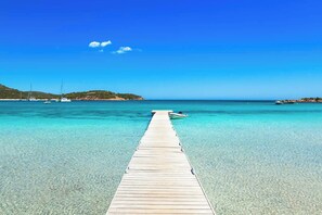 A wooden pier extending into a clear blue sea with boats anchored nearby. - Hôtel Aiglon Bylitis (Porto-Vecchio)