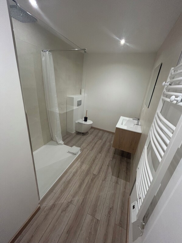 A modern bathroom with a glass shower enclosure, a toilet, and a sink with a towel rack. - Hôtel Aiglon Bylitis (Porto-Vecchio)