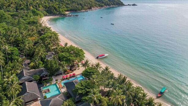 An aerial view of a tropical resort with a beach, a swimming pool, and a boat on the water. - Anantara Rasananda Koh Phangan Villas (Ko Pha-ngan)