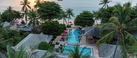 Un resort con piscina, playa y vista al océano.