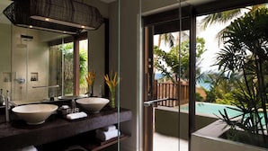 A modern bathroom with two large sinks, a large mirror, and a view of a pool and tropical plants. - Anantara Rasananda Koh Phangan Villas (Ko Pha-ngan)