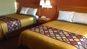 A hotel room with two beds, each with a patterned bedspread and pillows, a nightstand with a lamp, and a telephone. - Americas Best Value Inn Pryor (Pryor)
