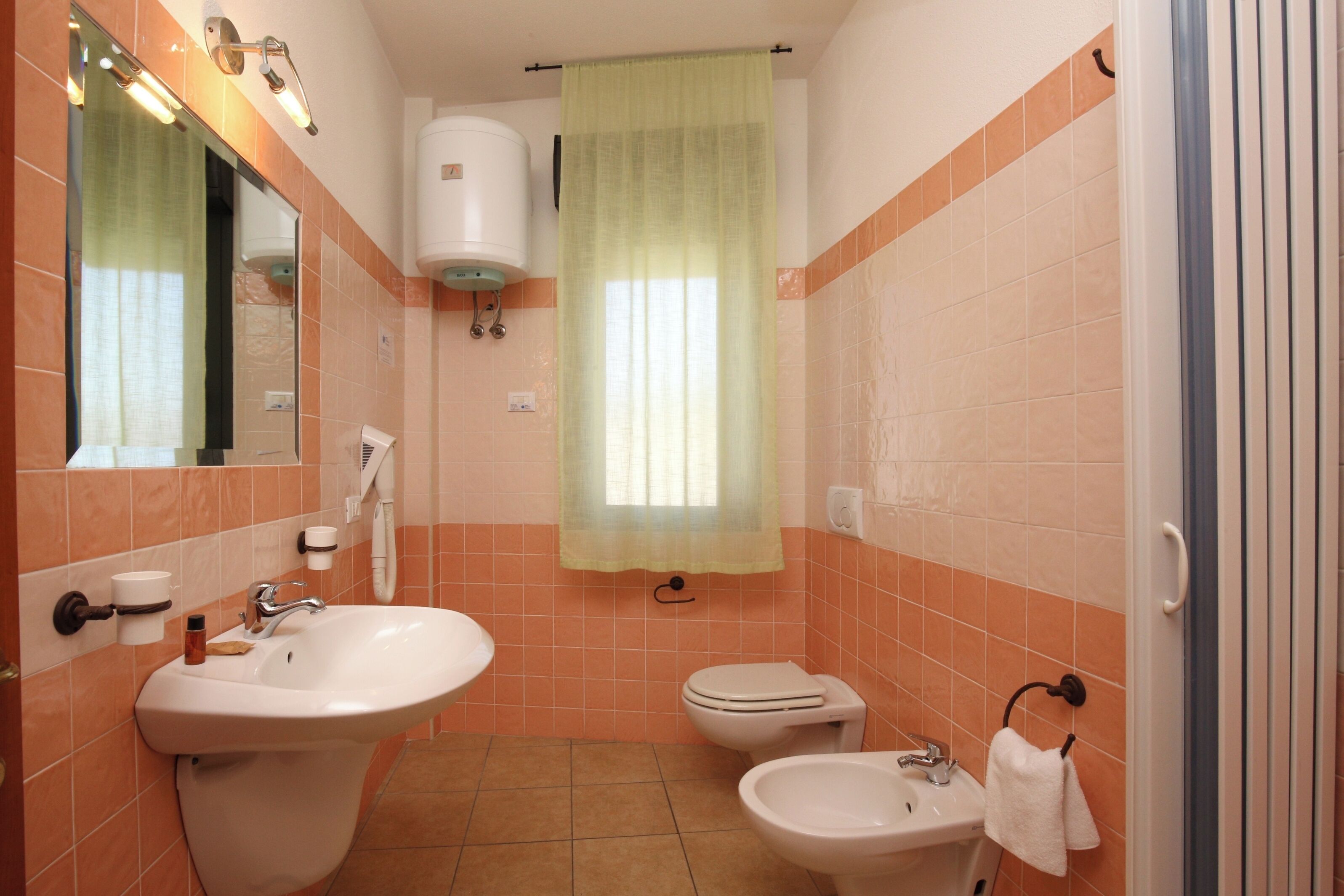 Un baño con lavamanos, bidé y retrete.