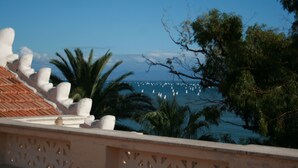 A coastal view with a tiled roof, palm trees, and a clear sky. - Villa Irlanda Grand Hotel (Gaeta)