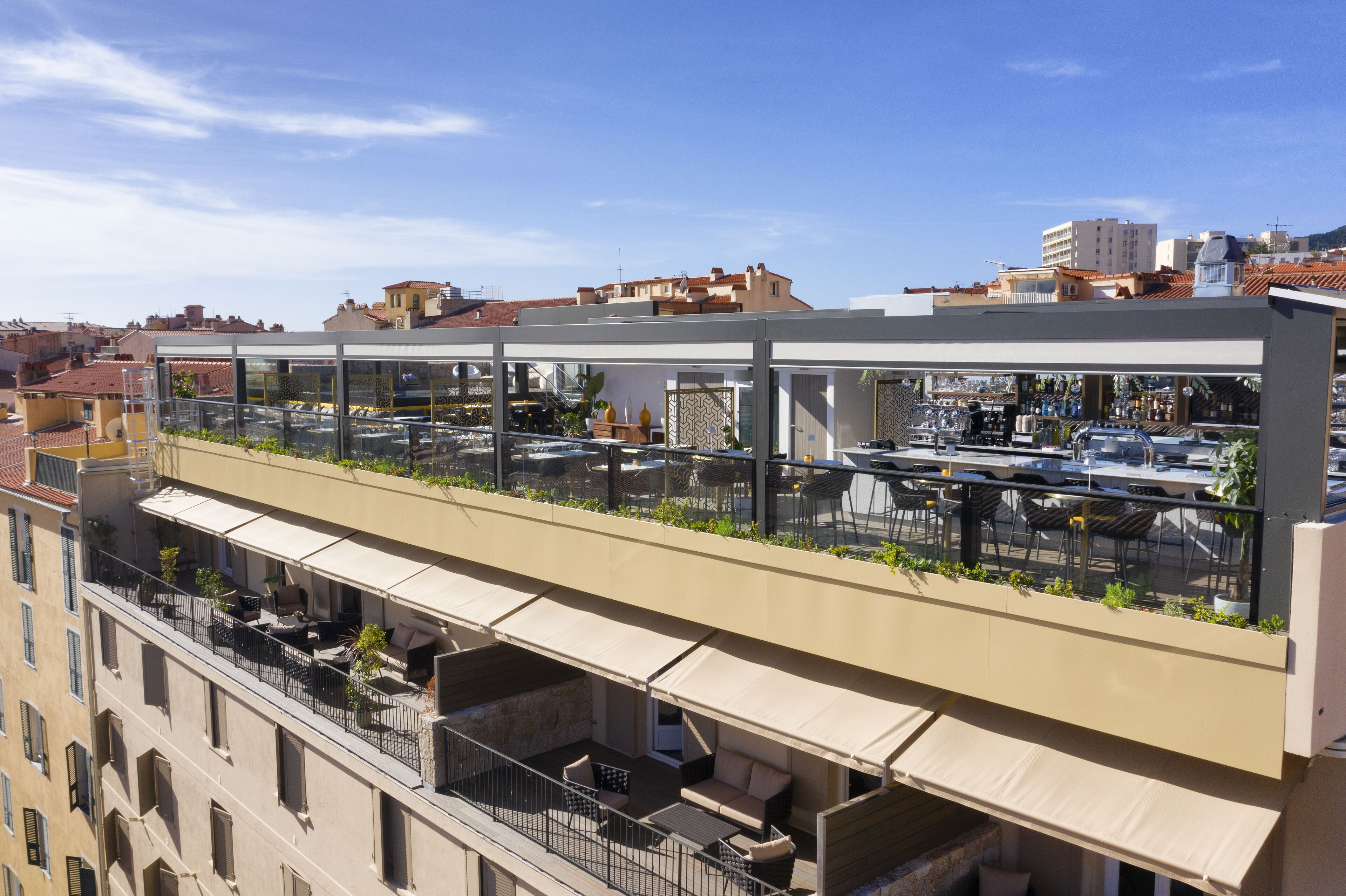 A rooftop terrace with outdoor seating and a view of the cityscape.