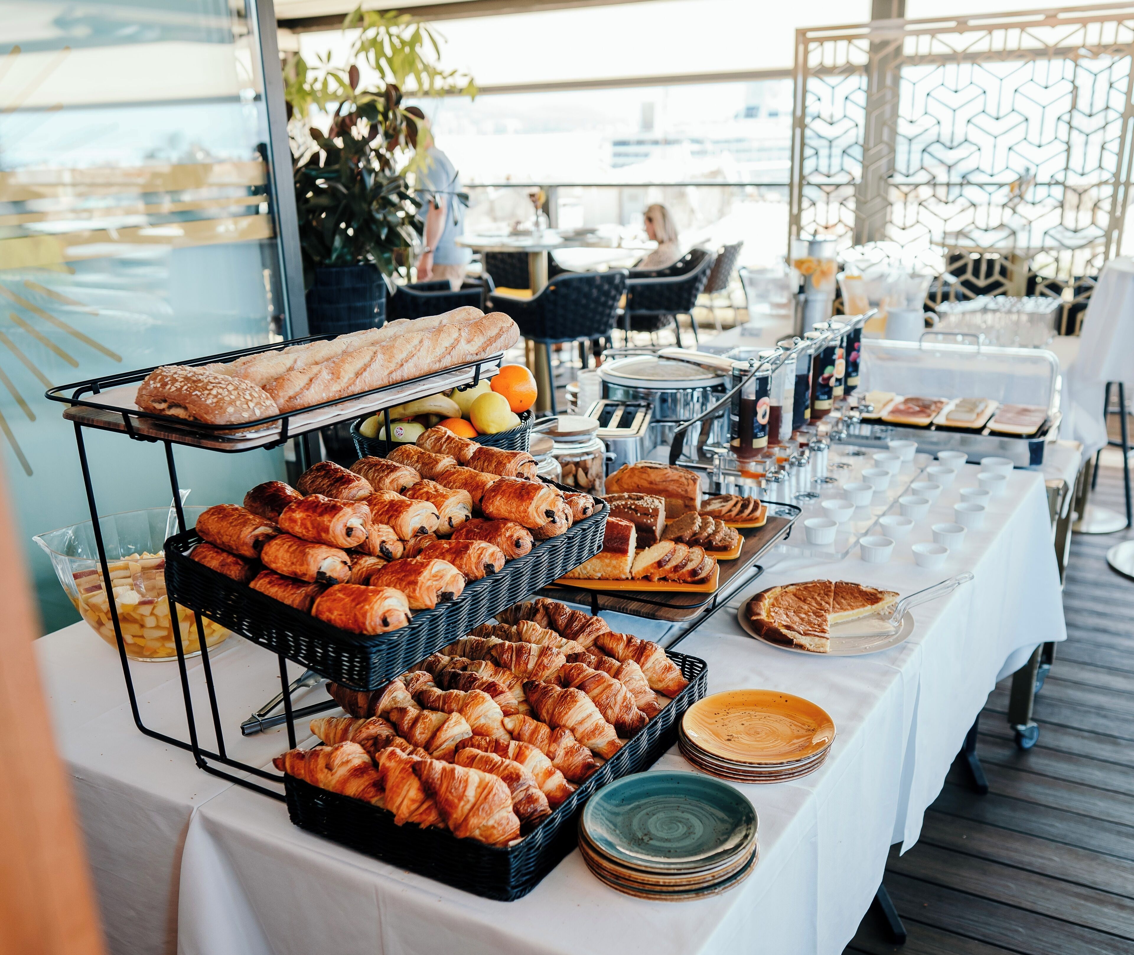 A buffet table with various pastries, fruits, and beverages.