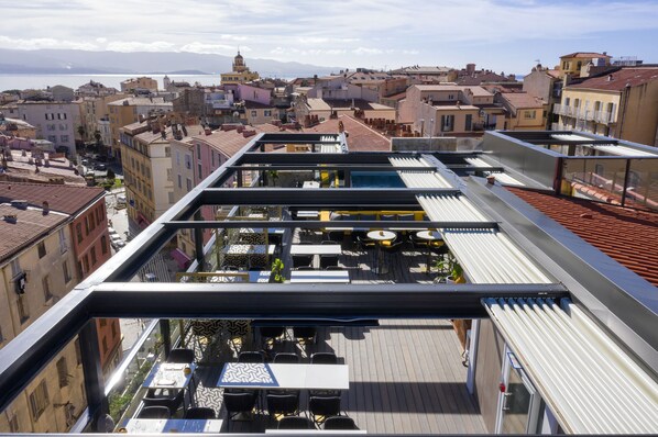 A rooftop terrace with outdoor seating and a view of the cityscape. - Hôtel Fesch & Spa (Ajaccio)