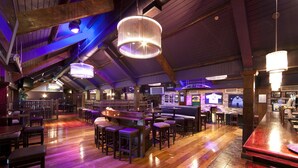 A spacious bar area with wooden flooring and multiple seating arrangements, including bar stools and high tables. - The Court Yard Hotel (Leixlip)