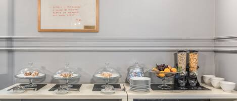 A breakfast buffet setup with various food items and a framed menu.