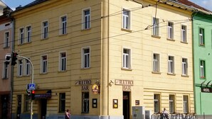 Ein gelbes Gebäude mit einem Schild 'Retro Bar', daneben ein grünes Gebäude und eine Fußgängerampel.