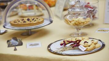 Une table de buffet où sont présentés divers desserts dans des récipients en verre et sur des assiettes.