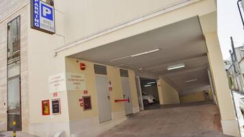 Guests can park their vehicles in the hotel's covered parking area, accessible via a ramp.