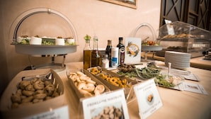 A buffet setup with various food items, including pastries, salads, and condiments.