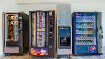 Four vending machines, including a Pepsi refrigerator and an ice dispenser, in a commercial setting.