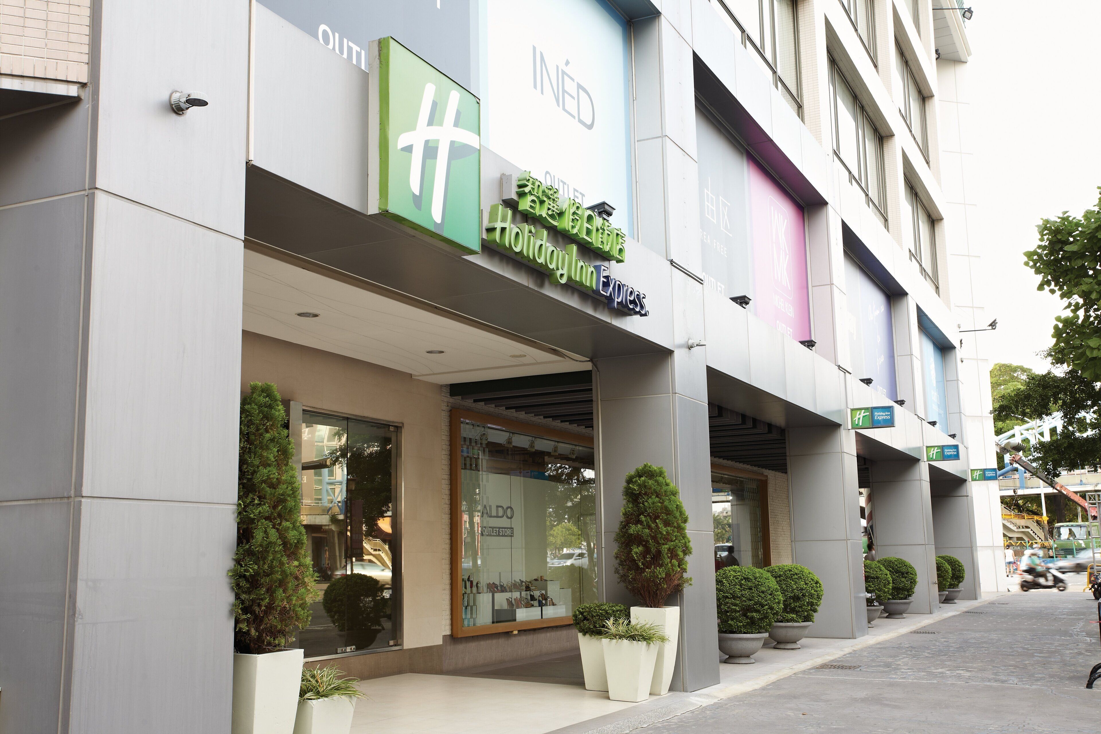 A hotel with a storefront labeled 'Holiday Inn Express' and a visible outlet store named 'ALDO'.
