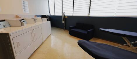 A clean, modern waiting area with a reception desk, seating, and a large window with blinds.