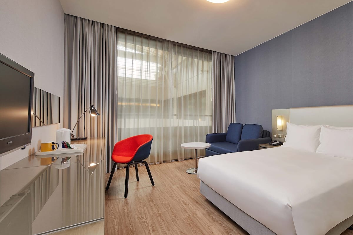 Relax in a spacious room with a large bed, flat-screen TV, and comfortable seating area.