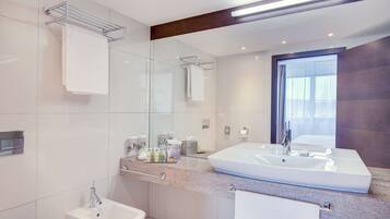 A modern bathroom with two sinks, a glass shower enclosure, and a large mirror.