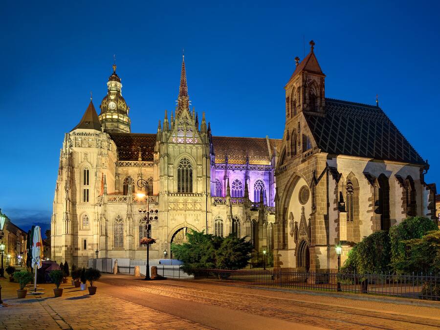 A historic cathedral with intricate architecture, large stained glass windows, and a prominent spire.