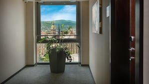 A hallway with a large window offering a view of a cityscape, including a prominent church with a golden dome.