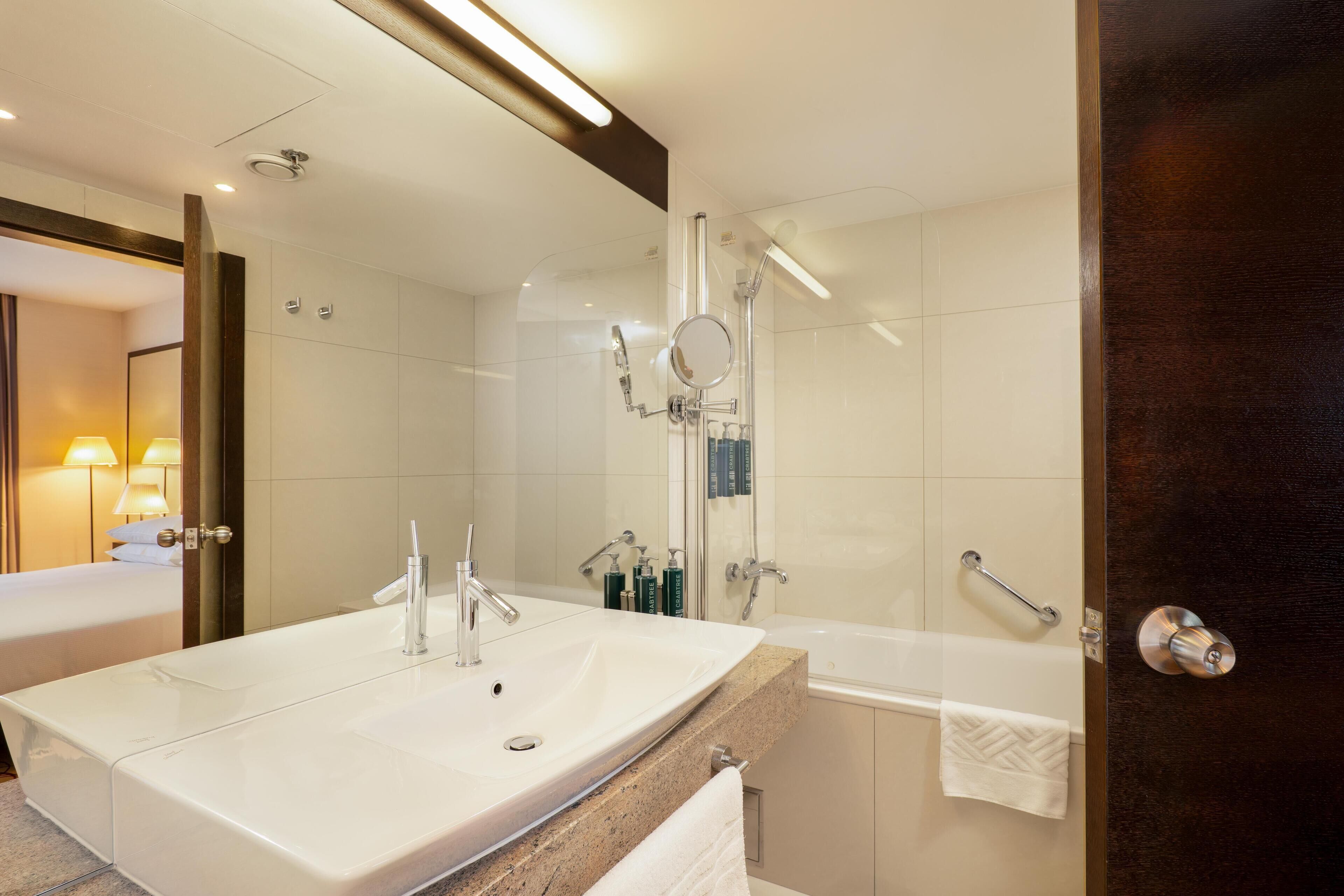 A modern bathroom with a large sink, a bathtub, and a shower.