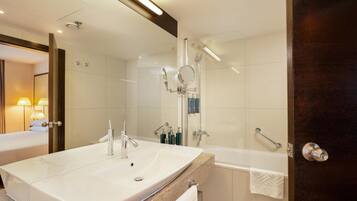 A modern bathroom with a large sink, a bathtub, and a shower.