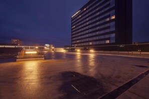 A multi-story hotel with illuminated windows and a parking area. - DoubleTree by Hilton Hotel Kosice (Kosice)