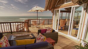 A deck with wicker furniture, a glass table, and an umbrella. - The Sands @ St Francis (Saint Francis Bay)